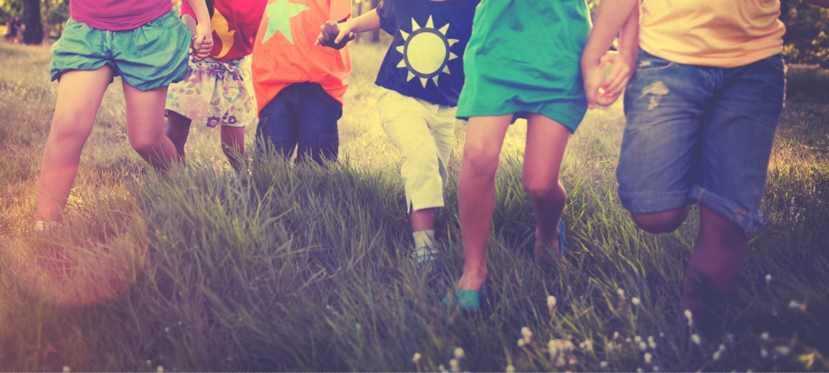 Kids running in a field during the summertime